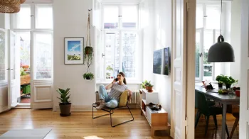 Sitting on her chair, a smiling woman chats on her cellphone